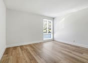 Thumbnail 78 of 92 - A room with wooden flooring and a window with blinds.