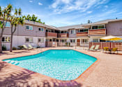 Thumbnail 9 of 25 - A swimming pool surrounded by a fence and chairs.