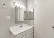 Thumbnail 42 of 42 - A white bathroom with a sink and mirror.