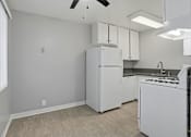 Thumbnail 43 of 55 - A kitchen with a white refrigerator and a fan on the ceiling.