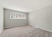 Thumbnail 22 of 33 - A room with a window and carpeted floor.