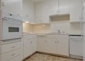 Thumbnail 14 of 34 - A kitchen with white cabinets and appliances.
