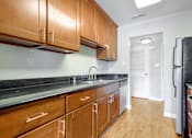 Thumbnail 20 of 37 - A kitchen with wooden cabinets and black appliances.