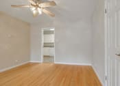 Thumbnail 30 of 37 - A room with a ceiling fan and wooden floors.