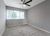 Thumbnail 29 of 53 - an empty living room with a ceiling fan and a window