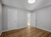 Thumbnail 5 of 31 - A room with two doors and a wooden floor.