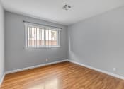 Thumbnail 35 of 38 - A room with wooden flooring and a window with blinds.