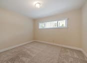 Thumbnail 22 of 29 - A room with a carpeted floor and a window with blinds.