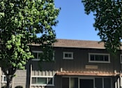 Thumbnail 6 of 30 - the front of a building with a tree in front of it
