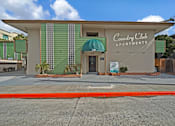 Thumbnail 2 of 16 - The front of the Country Club Apartments building