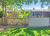 Thumbnail 1 of 34 - A house with a green lawn and a tree in front of it.