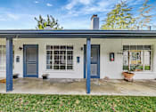 Thumbnail 11 of 21 - A house with blue doors and windows is shown.