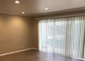 Thumbnail 13 of 22 - A room with wooden flooring and a window with blinds.