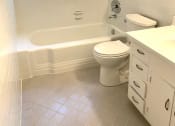 Thumbnail 28 of 31 - a bathroom with a toilet and a sink and a window
