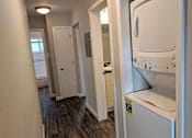 Thumbnail 18 of 63 - A white washing machine is in a small laundry room.