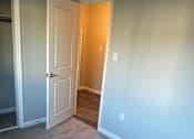 Thumbnail 6 of 14 - a room with a door and a carpeted floor