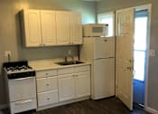 Thumbnail 26 of 31 - A kitchen with white appliances and cabinets.