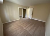 Thumbnail 13 of 23 - A room with carpeted flooring and two open doors.