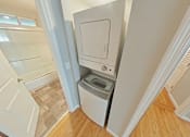 Thumbnail 25 of 47 - A white washing machine is in a small laundry room.