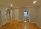 Thumbnail 36 of 47 - A room with wooden floors and white walls.