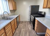 Thumbnail 23 of 31 - a kitchen with wooden floors and a stove and refrigerator
