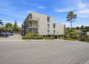Thumbnail 62 of 92 - A large building with a parking lot in front of it.