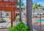 Thumbnail 21 of 25 - A red pergola is in front of a building with a pool.