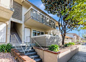 Thumbnail 31 of 51 - A modern two-story house with a balcony and stairs leading to the entrance.