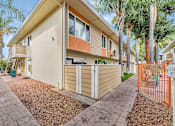 Thumbnail 13 of 51 - A beige house with a brown roof and a brown fence.