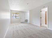 Thumbnail 29 of 29 - A sparsely furnished room with a door leading to another room.