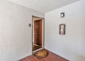 Thumbnail 36 of 52 - A brown door is at the end of a hallway with a number 29 on the wall above it.