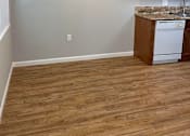 Thumbnail 20 of 22 - A kitchen with a white dishwasher and wooden cabinets.