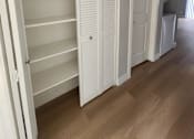 Thumbnail 49 of 51 - a closet with white shutters on the doors and a wooden floor