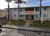 Thumbnail 13 of 14 - the front of an apartment building with palm trees