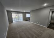 Thumbnail 5 of 16 - a empty living room with a large window and gray walls