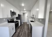 Thumbnail 11 of 16 - a kitchen with white cabinets and stainless steel appliances