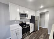 Thumbnail 7 of 16 - an empty kitchen with stainless steel appliances and white cabinets