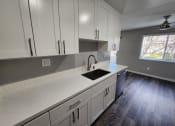 Thumbnail 8 of 16 - a kitchen with white cabinets and a sink and a window