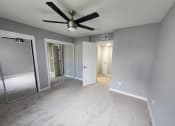 Thumbnail 9 of 16 - an empty bedroom with a ceiling fan and mirrors