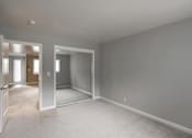 Thumbnail 33 of 60 - A large empty room with a carpeted floor and white walls.