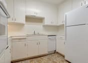 Thumbnail 16 of 34 - A kitchen with white cabinets and appliances.