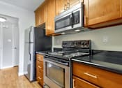 Thumbnail 19 of 37 - A kitchen with a black refrigerator, stove, and oven.