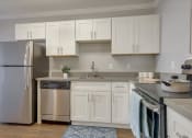 Thumbnail 14 of 35 - A kitchen with white cabinets and a stainless steel refrigerator.