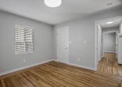 Thumbnail 3 of 31 - A room with wooden floors and white walls.