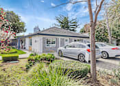 Thumbnail 4 of 21 - A grey house with a silver car parked in front.