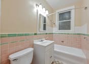 Thumbnail 38 of 42 - A white toilet sits next to a white sink in a bathroom.