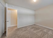 Thumbnail 16 of 29 - A room with a carpeted floor and a door.