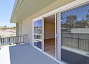 Thumbnail 59 of 92 - A balcony with a glass door and a railing.