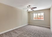 Thumbnail 6 of 41 - A room with a ceiling fan and a window.