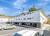 Thumbnail 43 of 43 - A white building with a parking lot in front of it.